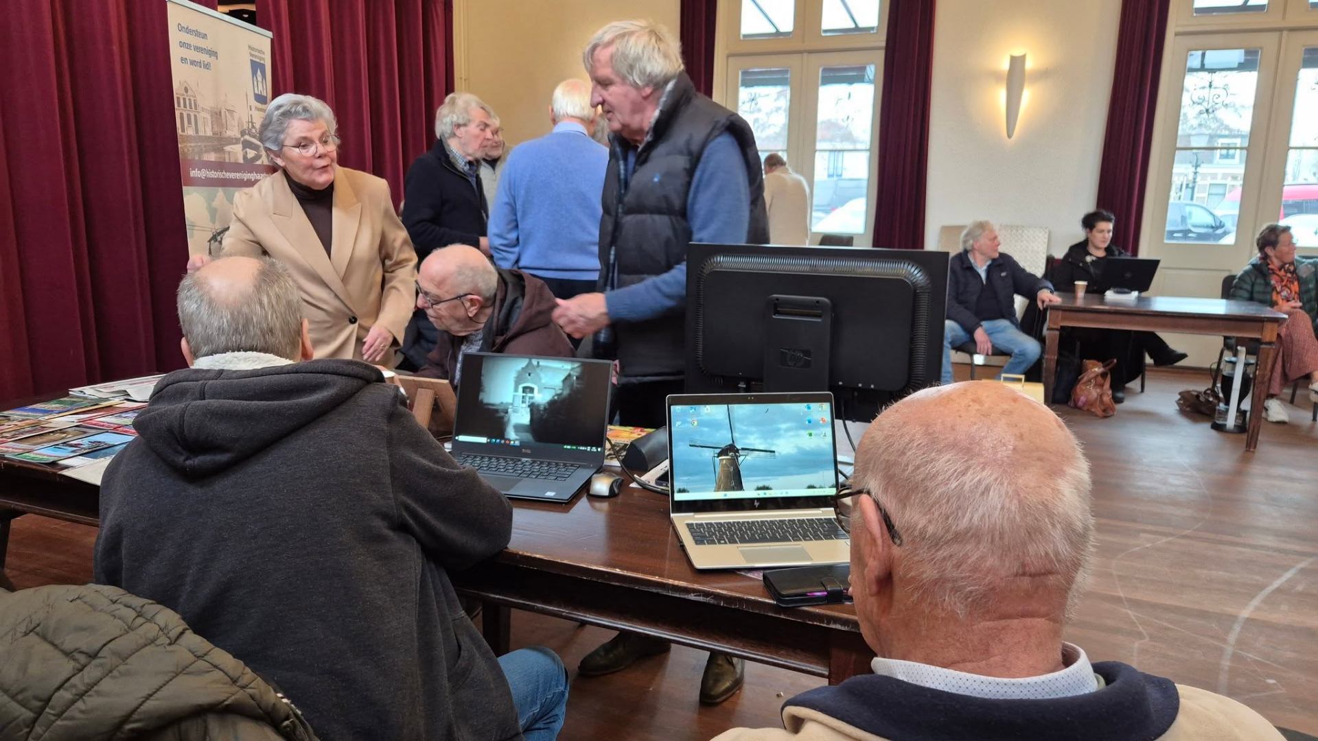 Bezoekers aan tafel met laptops tijdens het Historisch Café in Haastrecht
